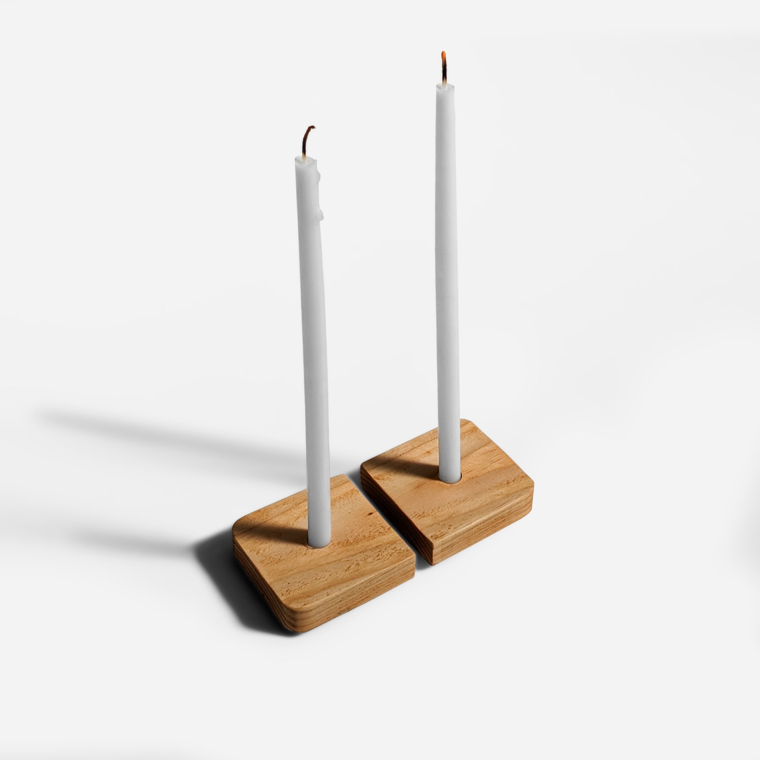 Set of two Enlightened candle holders made from salvaged Doug Fir wood, showcasing unique color variations and a contemporary design.