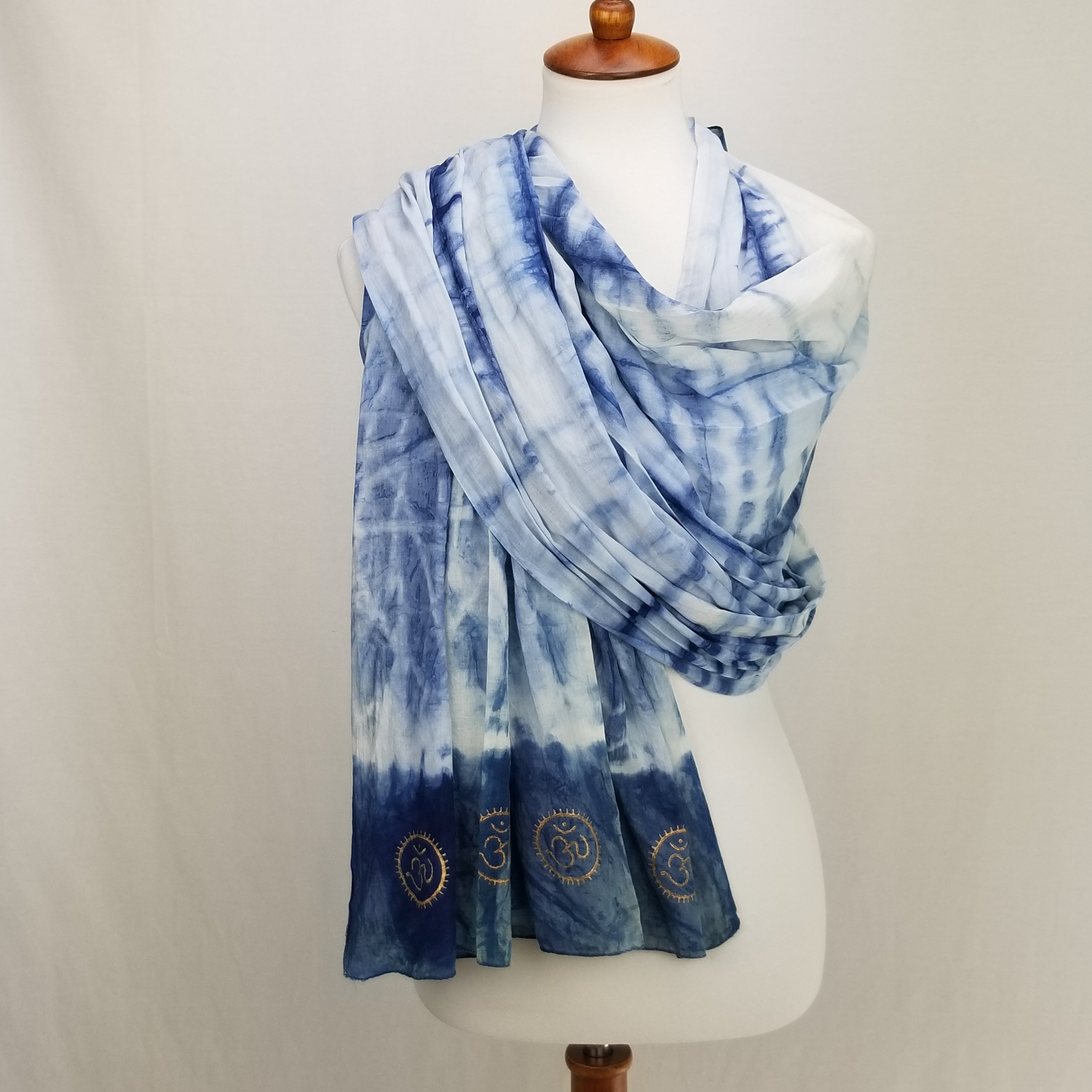 Eternity Indigo Cotton Scarf featuring hand-dyed indigo fabric and golden OM symbols at both ends.