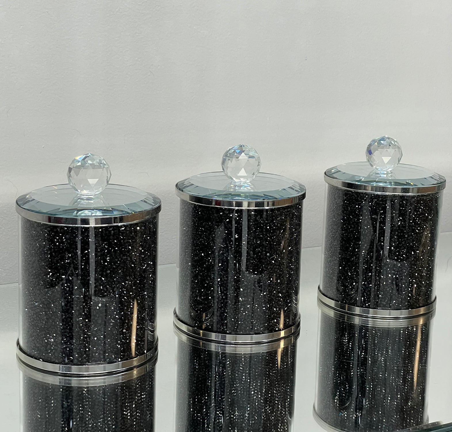 Exquisite three glass canister set featuring black crushed diamond glass with decorative chrome base and glass lids.