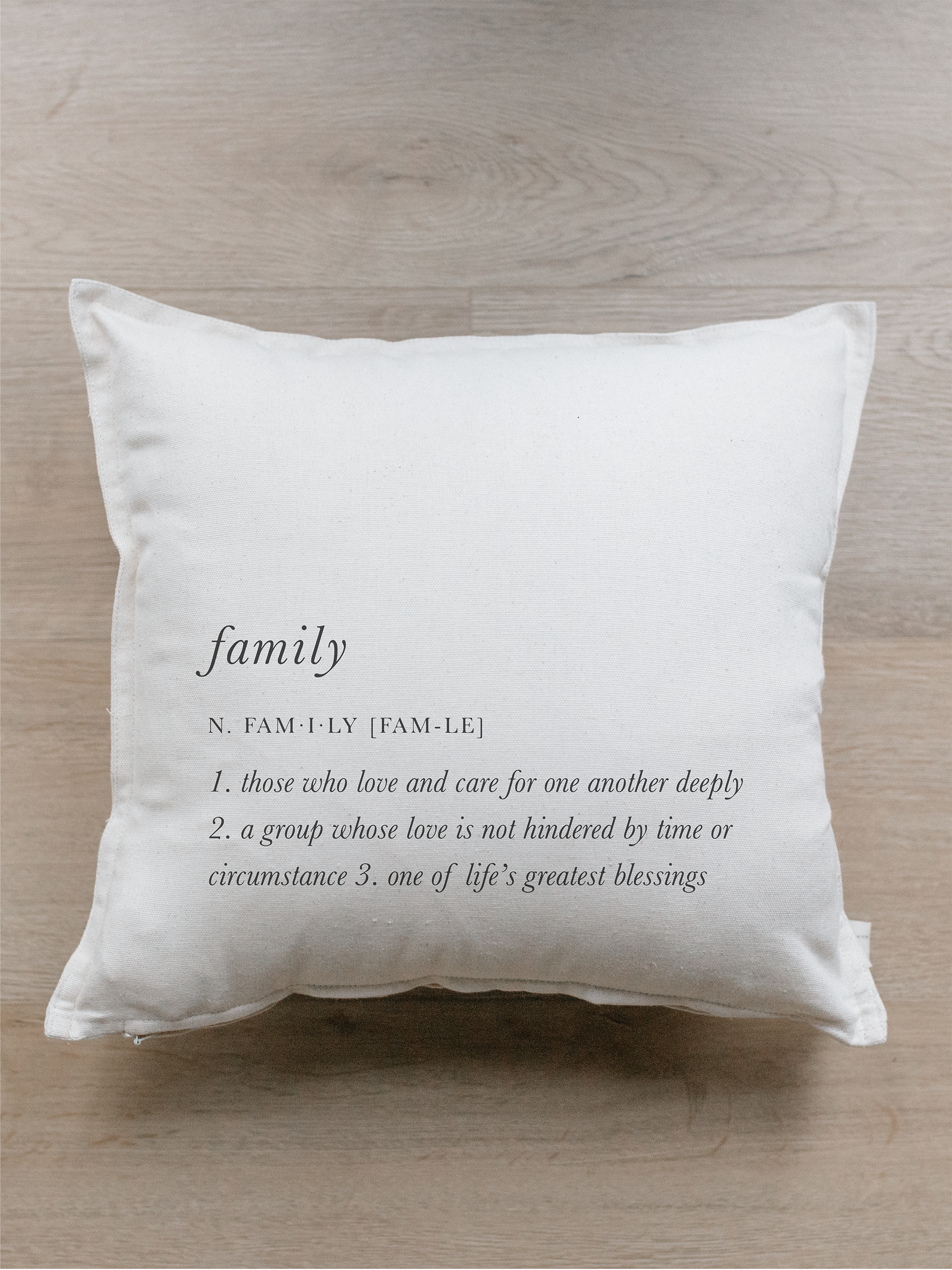 A cozy Family Definition Pillow featuring unique calligraphy designs on soft, natural cotton fabric, perfect for home decor.