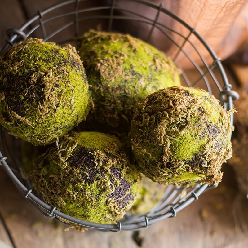 A realistic faux artificial decorative moss ball in green and brown colors, showcasing its lifelike texture and design.