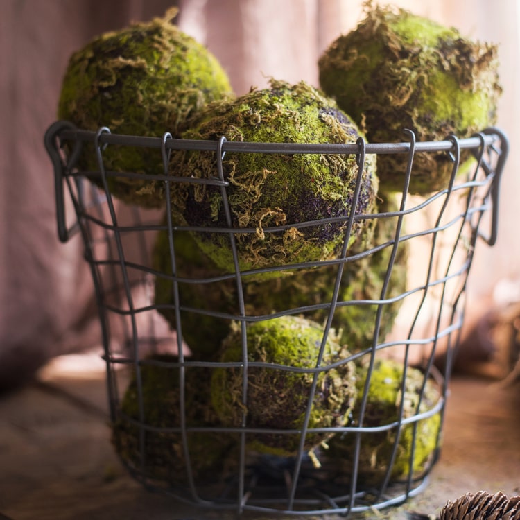 A realistic faux artificial decorative moss ball in green and brown colors, showcasing its lifelike texture and design.