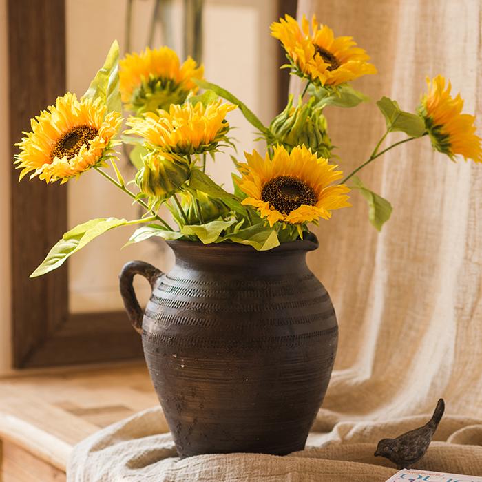 A vibrant 28-inch tall faux silk sunflower stem with a large bloom and a bud, showcasing bright yellow petals and green leaves.