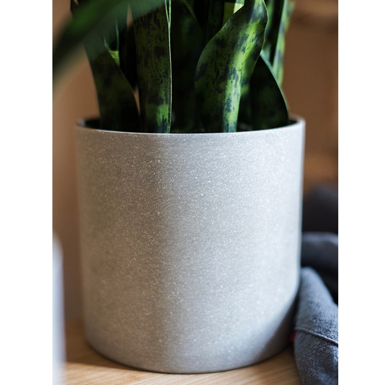 A realistic faux artificial snake plant in a decorative pot, showcasing vibrant green leaves and a modern design.