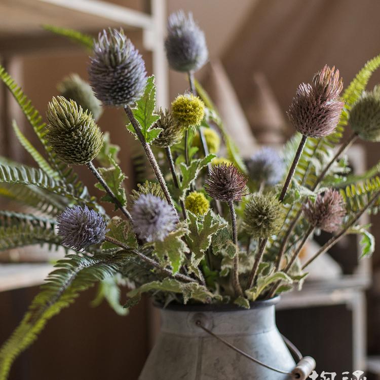 A 26-inch tall faux silk artificial thistle flower stem with three blooms in blue, green, and red, showcasing realistic petals and elegant design.