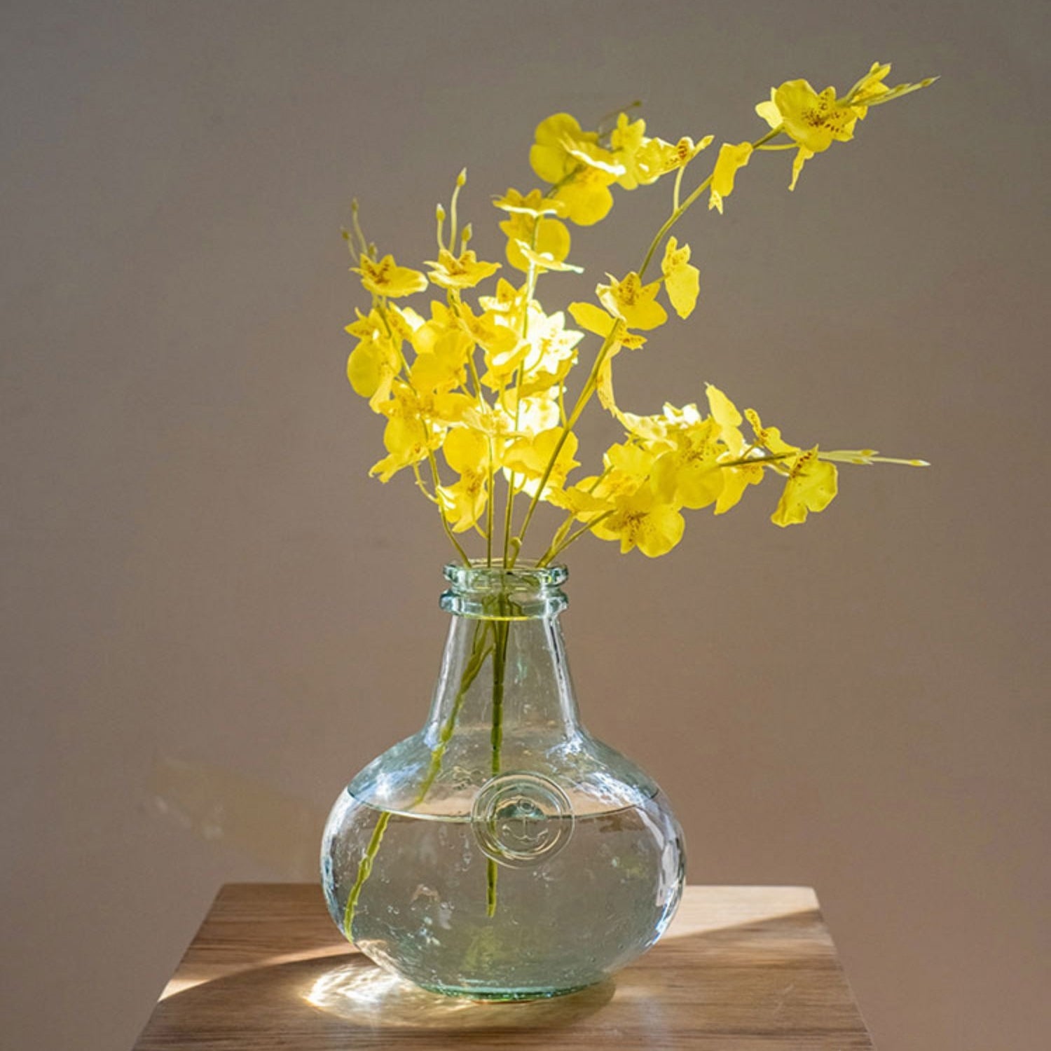 A vibrant yellow faux silk artificial Dancing Lady Orchid stem, 19 inches tall, showcasing realistic petals and leaves.