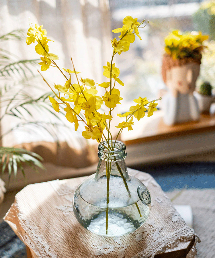 A vibrant yellow faux silk artificial Dancing Lady Orchid stem, 19 inches tall, showcasing realistic petals and leaves.