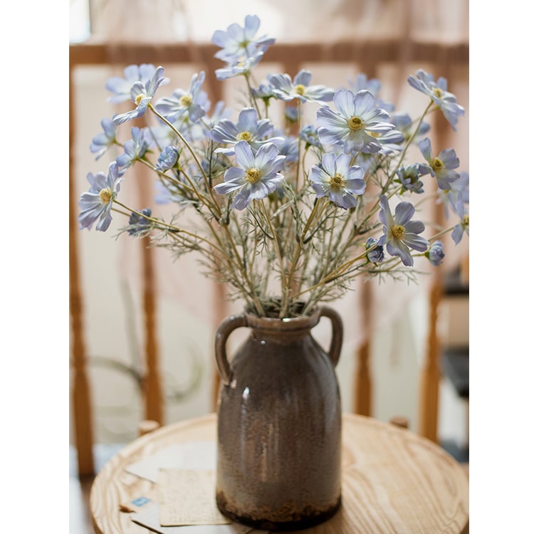 A 24-inch tall Faux Silk Cosmos Stem in vibrant blue, showcasing delicate petals and realistic design, perfect for floral arrangements.