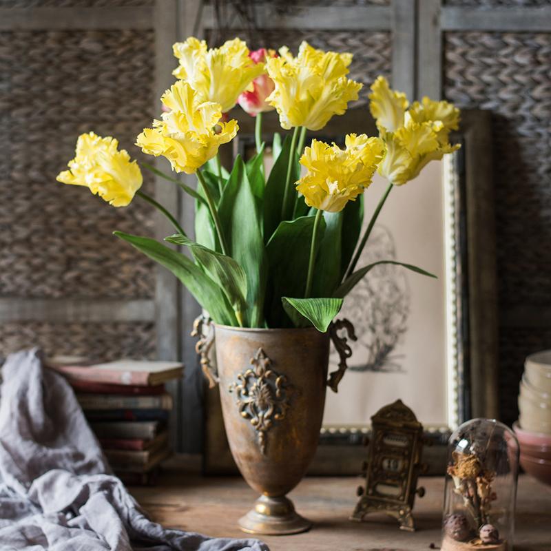 A vibrant yellow faux silk Flame Tulip flower stem, 24 inches tall, featuring lush green leaves and a realistic bloom.