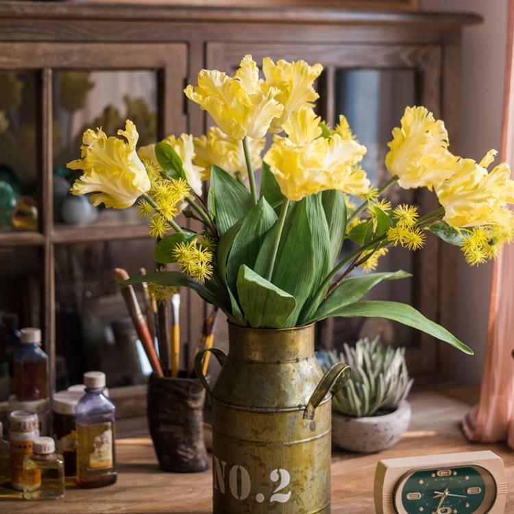 A vibrant yellow faux silk Flame Tulip flower stem, 24 inches tall, featuring lush green leaves and a realistic bloom.