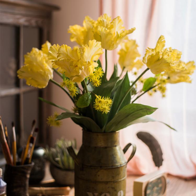 A vibrant yellow faux silk Flame Tulip flower stem, 24 inches tall, featuring lush green leaves and a realistic bloom.