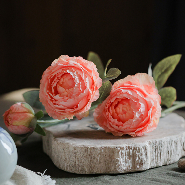 A 27.5-inch tall faux silk peony stem featuring two vibrant blooms and one bud, available in champagne, pink, red, and white colors.