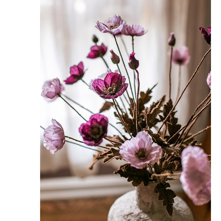 A 23-inch tall faux silk rustic poppy flower stem in purple with three blooms and one bud, featuring green leaves.