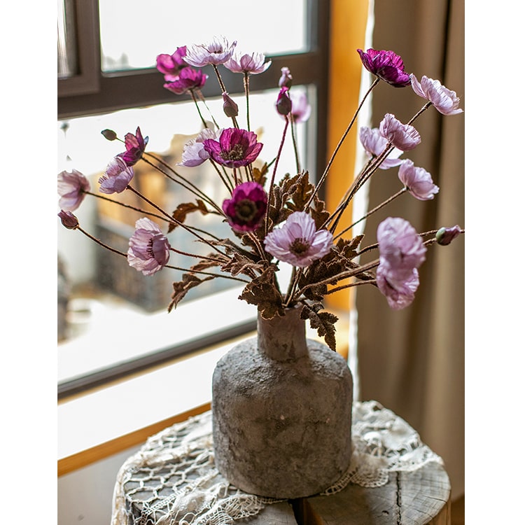 A 23-inch tall faux silk rustic poppy flower stem in purple with three blooms and one bud, featuring green leaves.