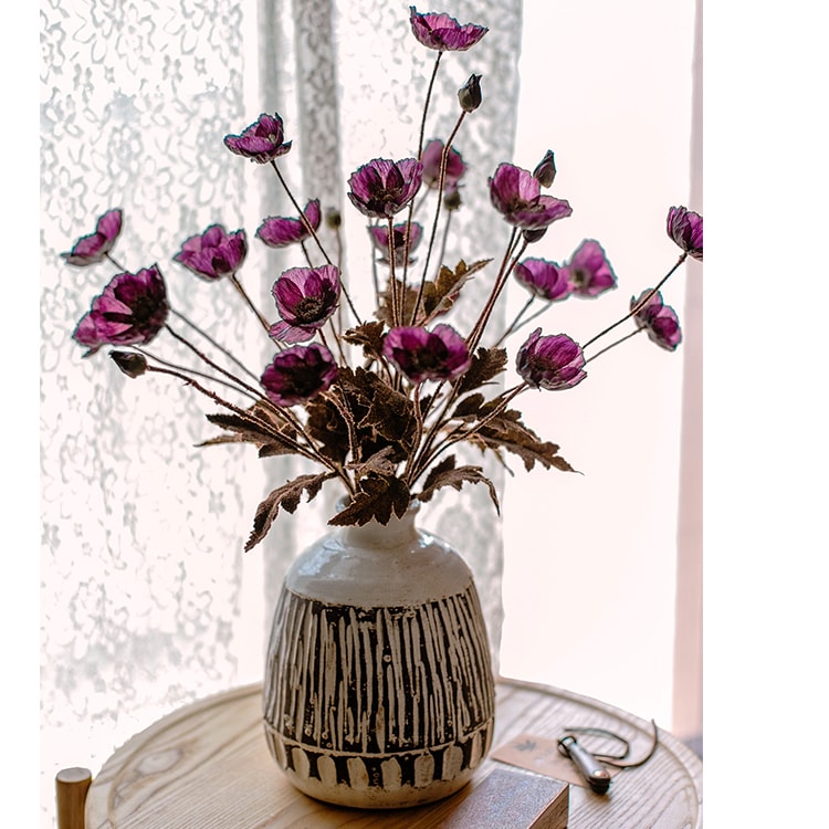 A 23-inch tall faux silk rustic poppy flower stem in purple with three blooms and one bud, featuring green leaves.