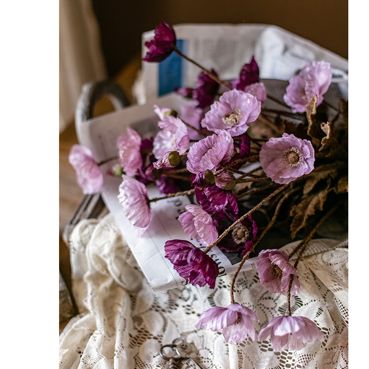 A 23-inch tall faux silk rustic poppy flower stem in purple with three blooms and one bud, featuring green leaves.