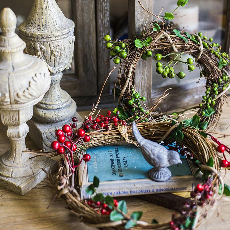 A beautifully crafted faux berry wreath made from natural rattan willow, featuring vibrant red and green artificial berries, perfect for home decor.