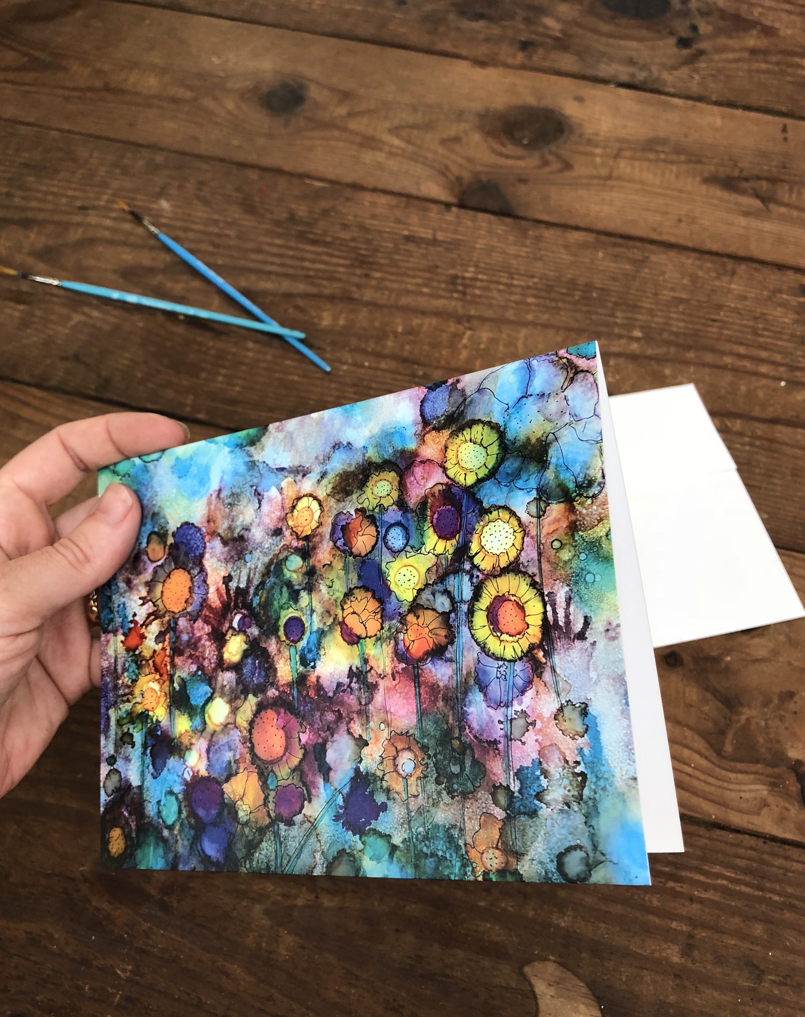 A vibrant greeting card featuring abstract flowers in vivid colors against a soft watercolor background, perfect for gifting or framing.