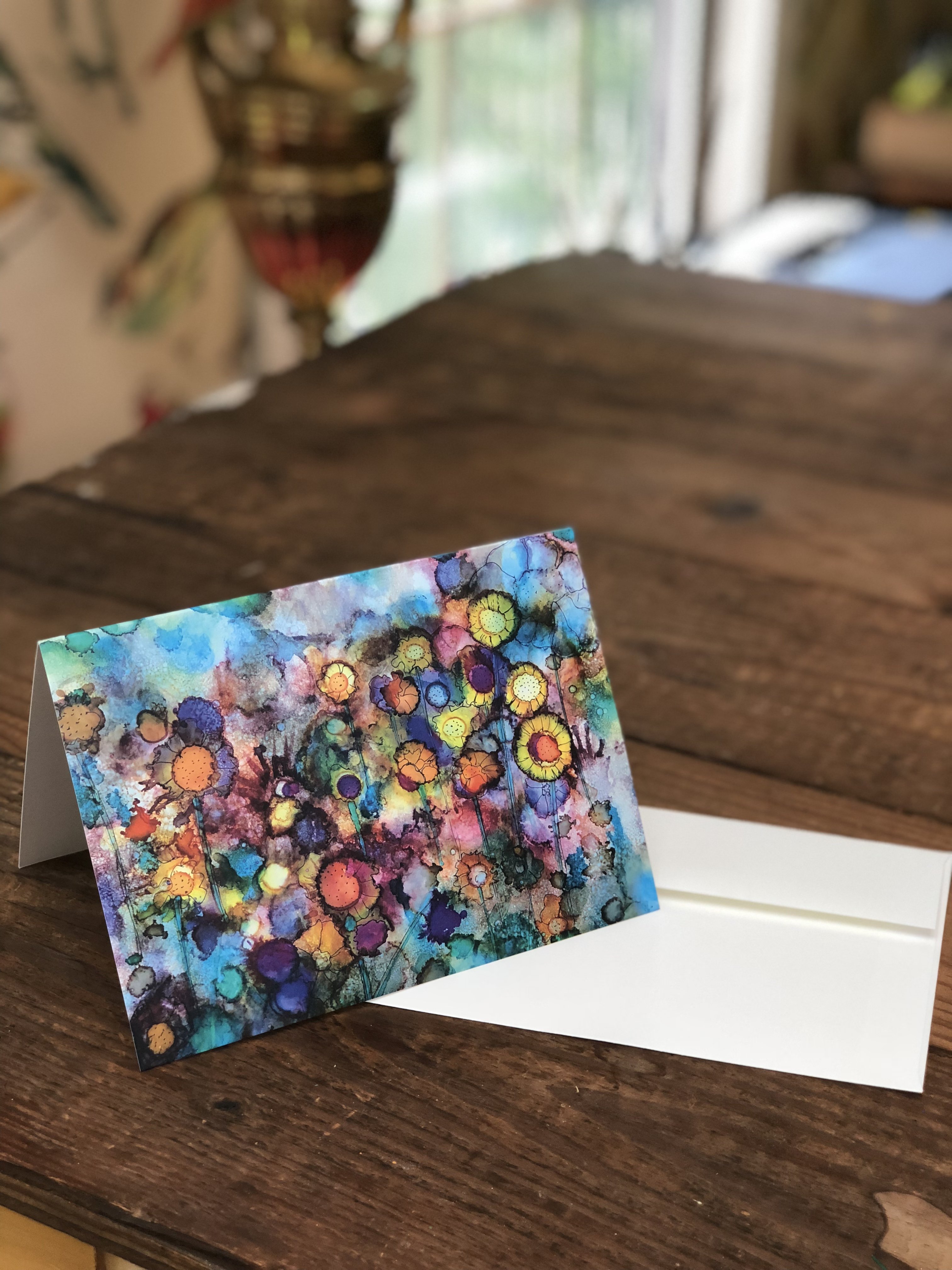 A vibrant greeting card featuring abstract flowers in vivid colors against a soft watercolor background, perfect for gifting or framing.