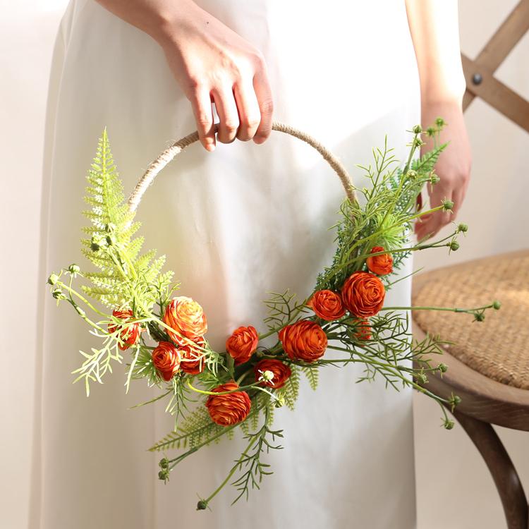 Floral Hoop featuring vibrant orange buttercup flowers and lush greenery, perfect for weddings and home decor.