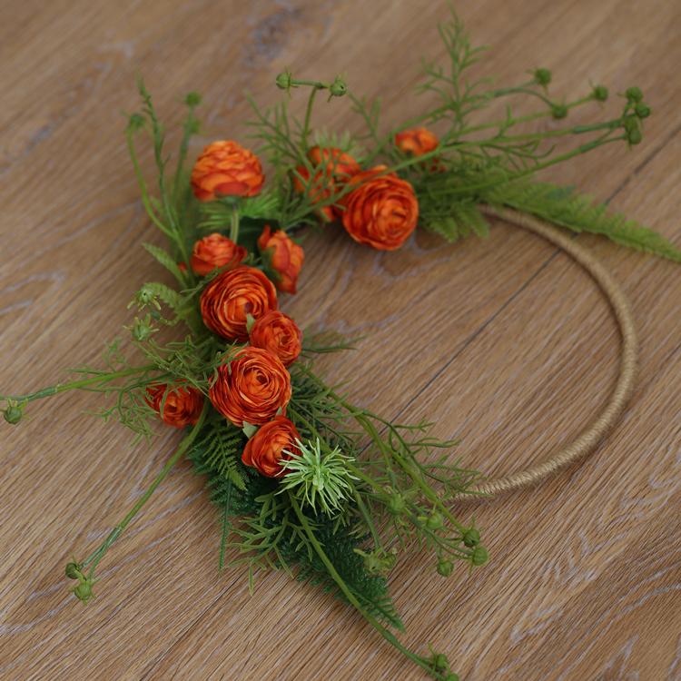 Floral Hoop featuring vibrant orange buttercup flowers and lush greenery, perfect for weddings and home decor.