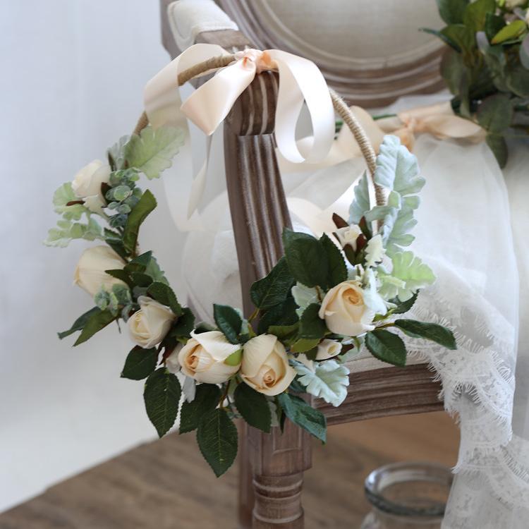 A beautiful 9-inch floral hoop featuring artificial white roses and lush green leaves, perfect for weddings and home decor.