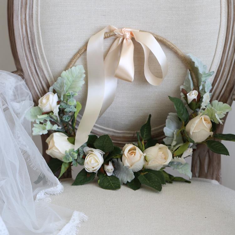 A beautiful 9-inch floral hoop featuring artificial white roses and lush green leaves, perfect for weddings and home decor.