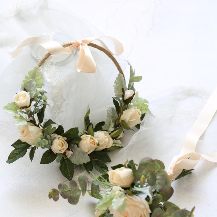 A beautiful 9-inch floral hoop featuring artificial white roses and lush green leaves, perfect for weddings and home decor.