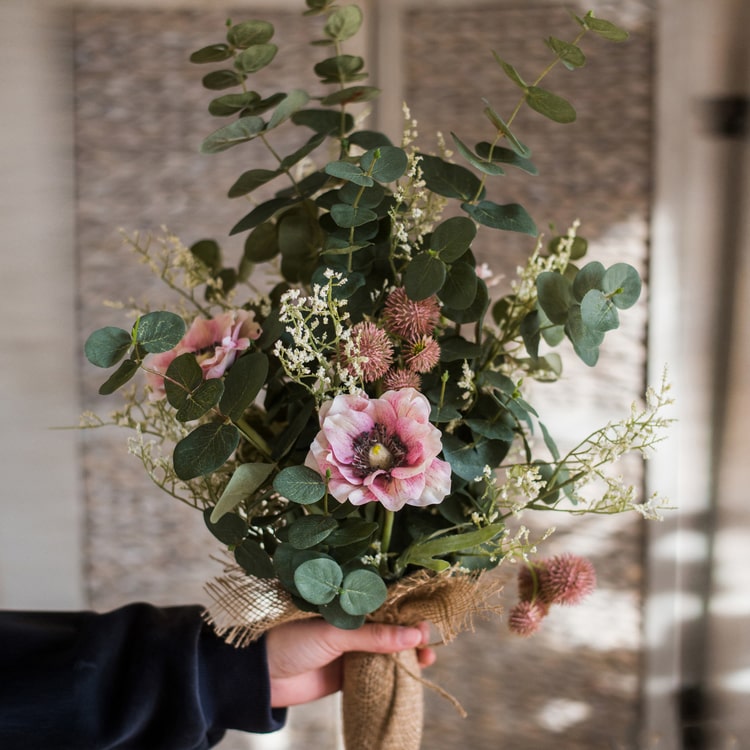 A beautiful handmade artificial flower bouquet featuring pink anemones and green eucalyptus, standing 21 inches tall.