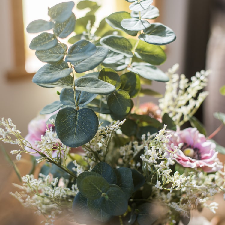 A beautiful handmade artificial flower bouquet featuring pink anemones and green eucalyptus, standing 21 inches tall.