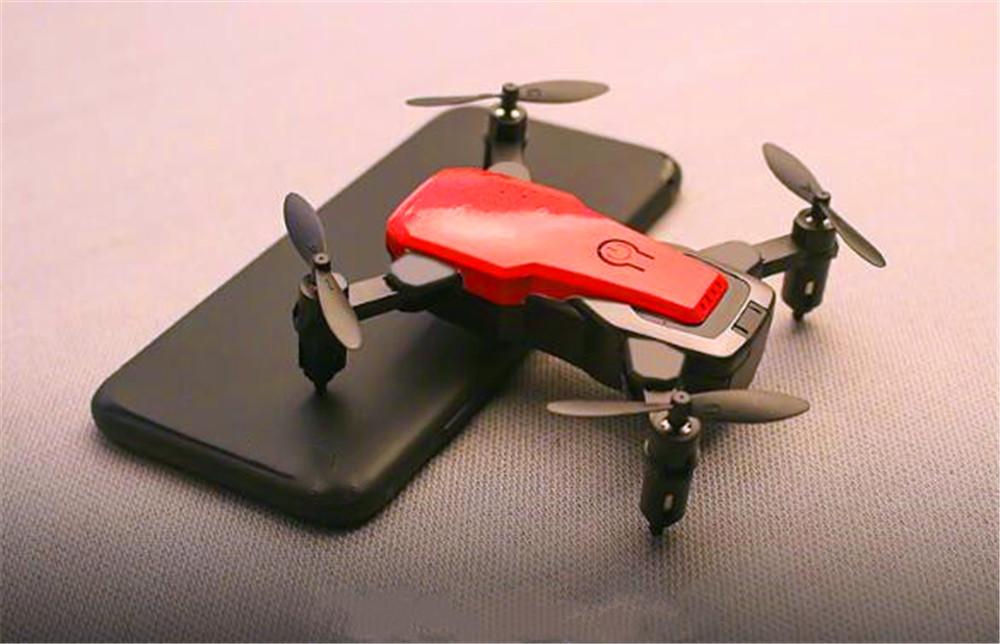 Foldable Mini Drone with HD camera in flight, showcasing its compact design and advanced features.