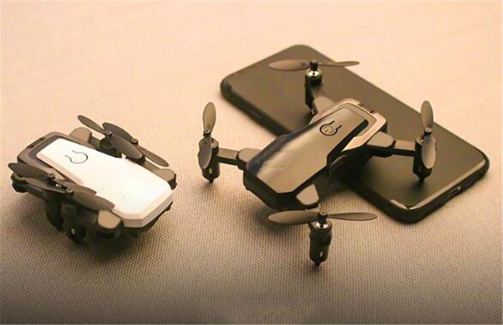 Foldable Mini Drone with HD camera in flight, showcasing its compact design and advanced features.