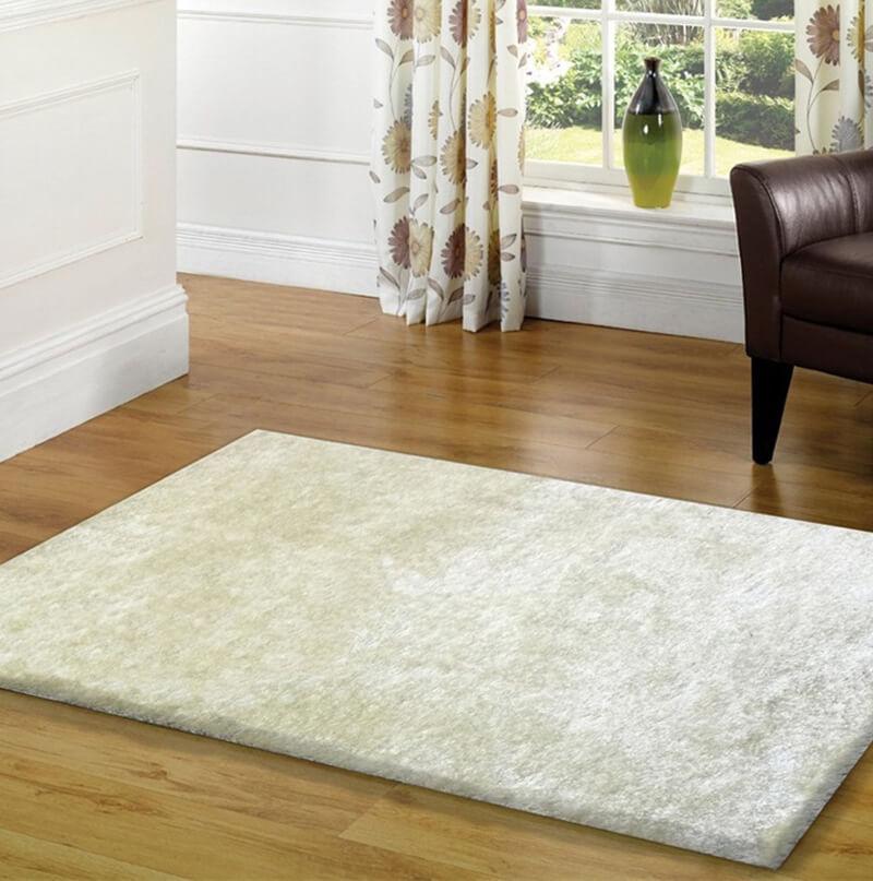 Fuzzy White Area Rug in pearl white color, showcasing its soft shaggy texture and cotton backing, perfect for enhancing home decor.