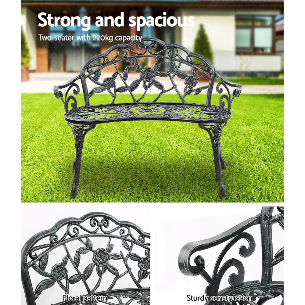 Gardeon Victorian Garden Bench in green with ornate aluminum seat and floral-patterned backrest, set against a garden backdrop.