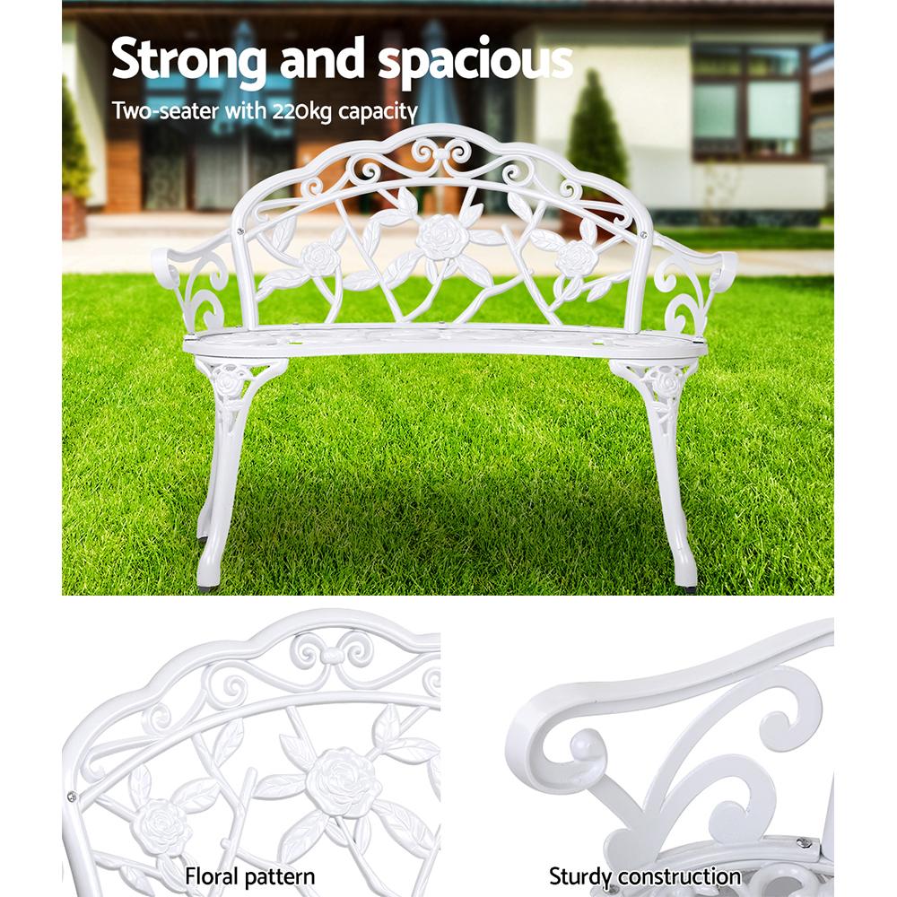 Gardeon Victorian Garden Bench in white with ornate aluminum seat and floral-patterned backrest, set against a garden backdrop.