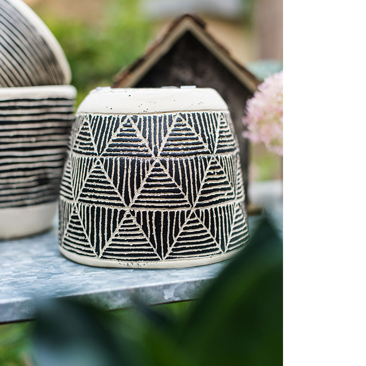 Geometric Art Concrete Flower Pot in black and cream colors, showcasing its modern design and drainage hole.