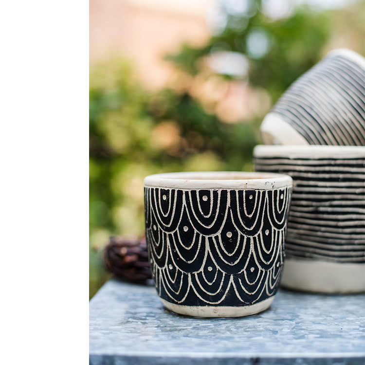 Geometric Art Concrete Flower Pot in black and cream colors, showcasing its modern design and drainage hole.