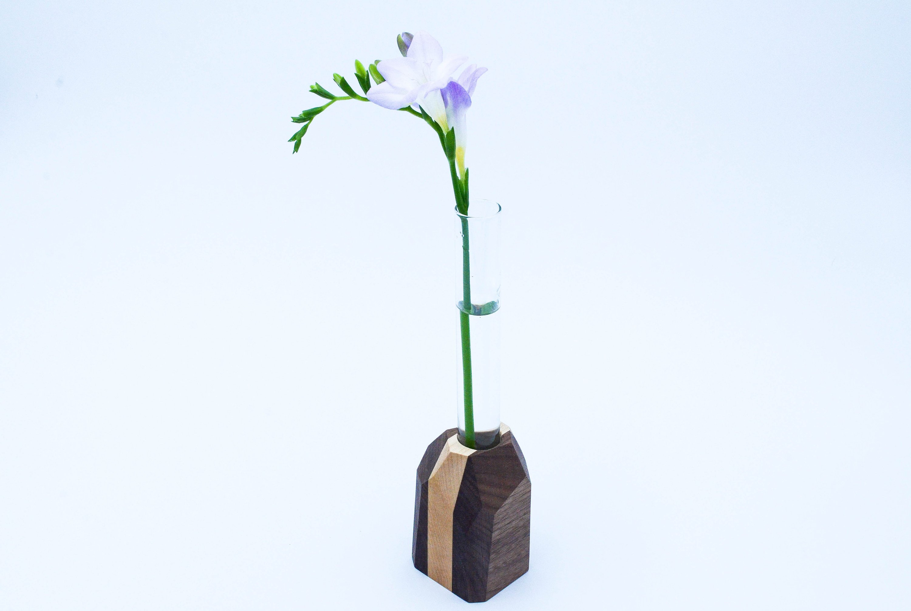 A handcrafted Geometric Flower Vase made from Maple and Black Walnut hardwood, showcasing its modern design and unique wood grain patterns.