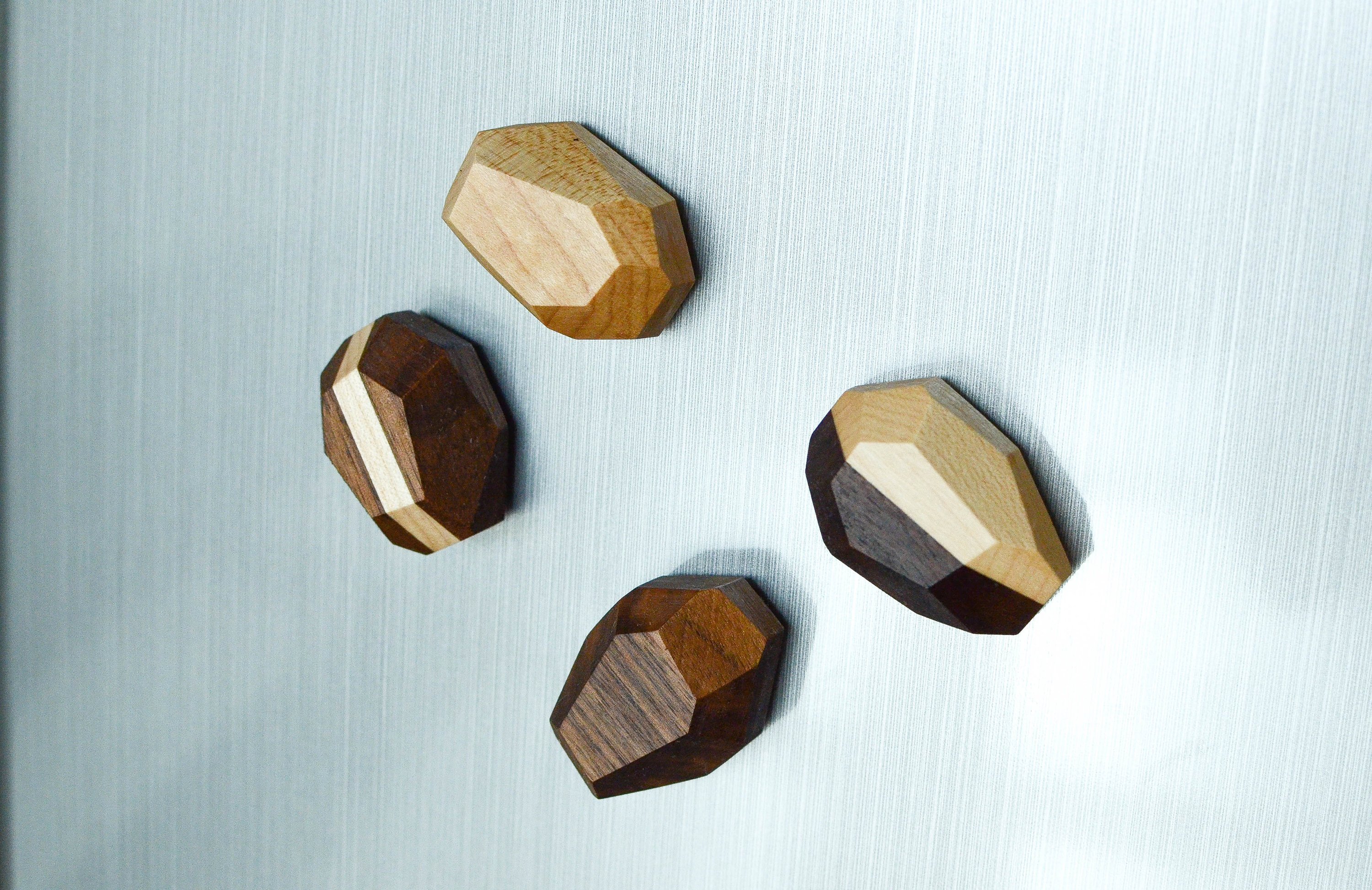 Set of 4 unique geometric wooden magnets in various shapes, crafted from Black Walnut and Maple, showcasing a natural finish.