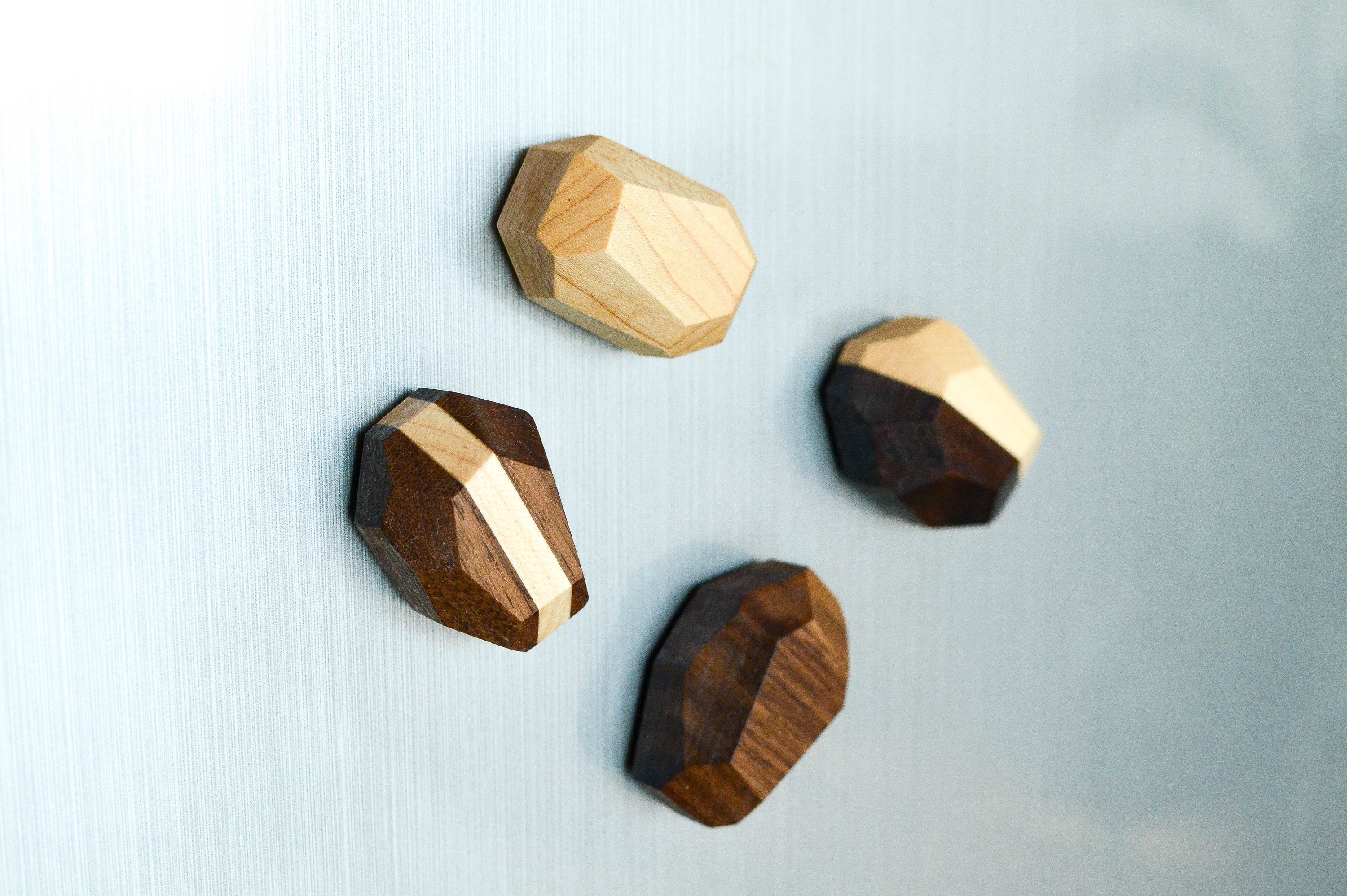 Set of 4 unique geometric wooden magnets in various shapes, crafted from Black Walnut and Maple, showcasing a natural finish.