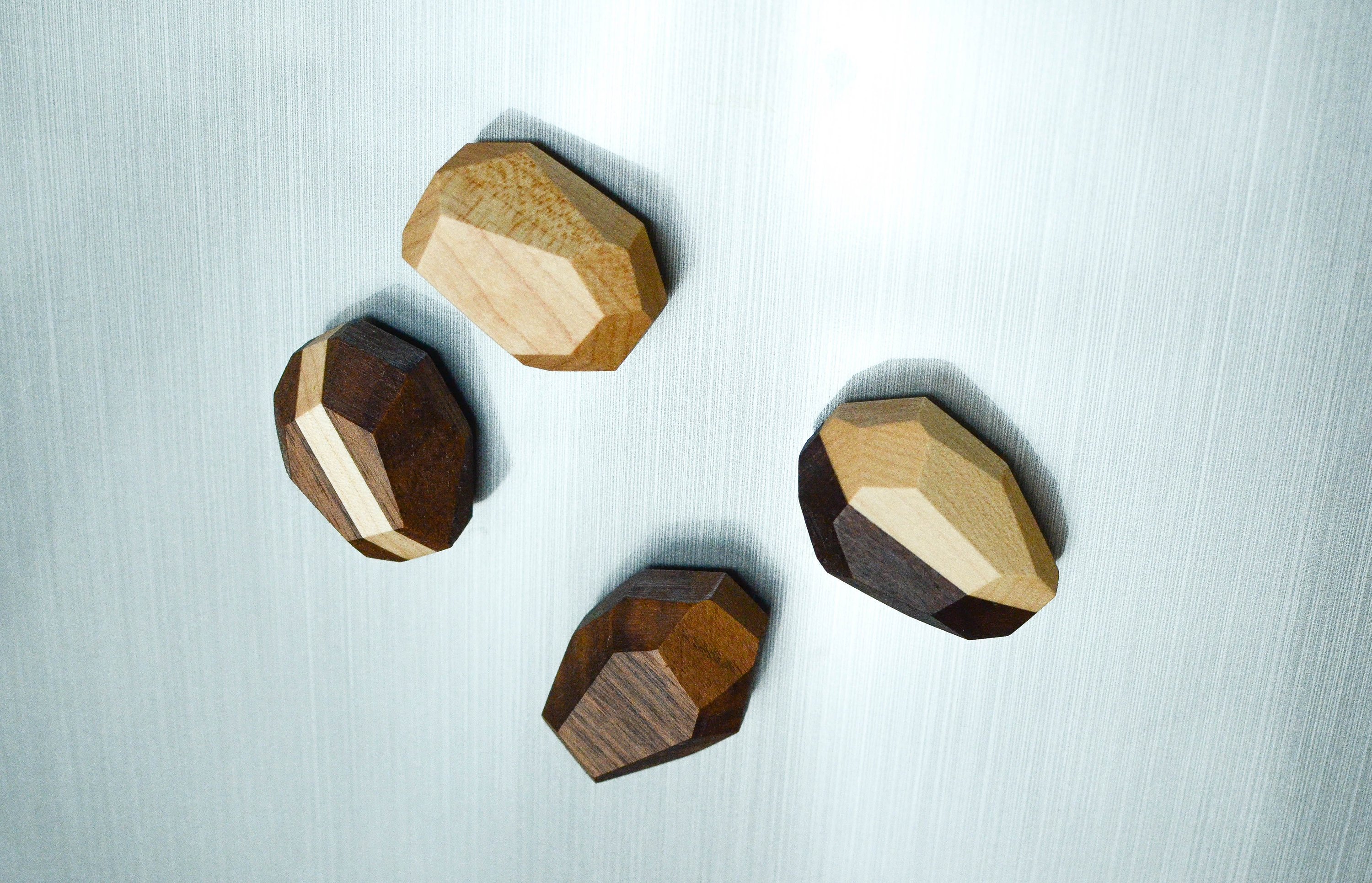 Set of 4 unique geometric wooden magnets in various shapes, crafted from Black Walnut and Maple, showcasing a natural finish.