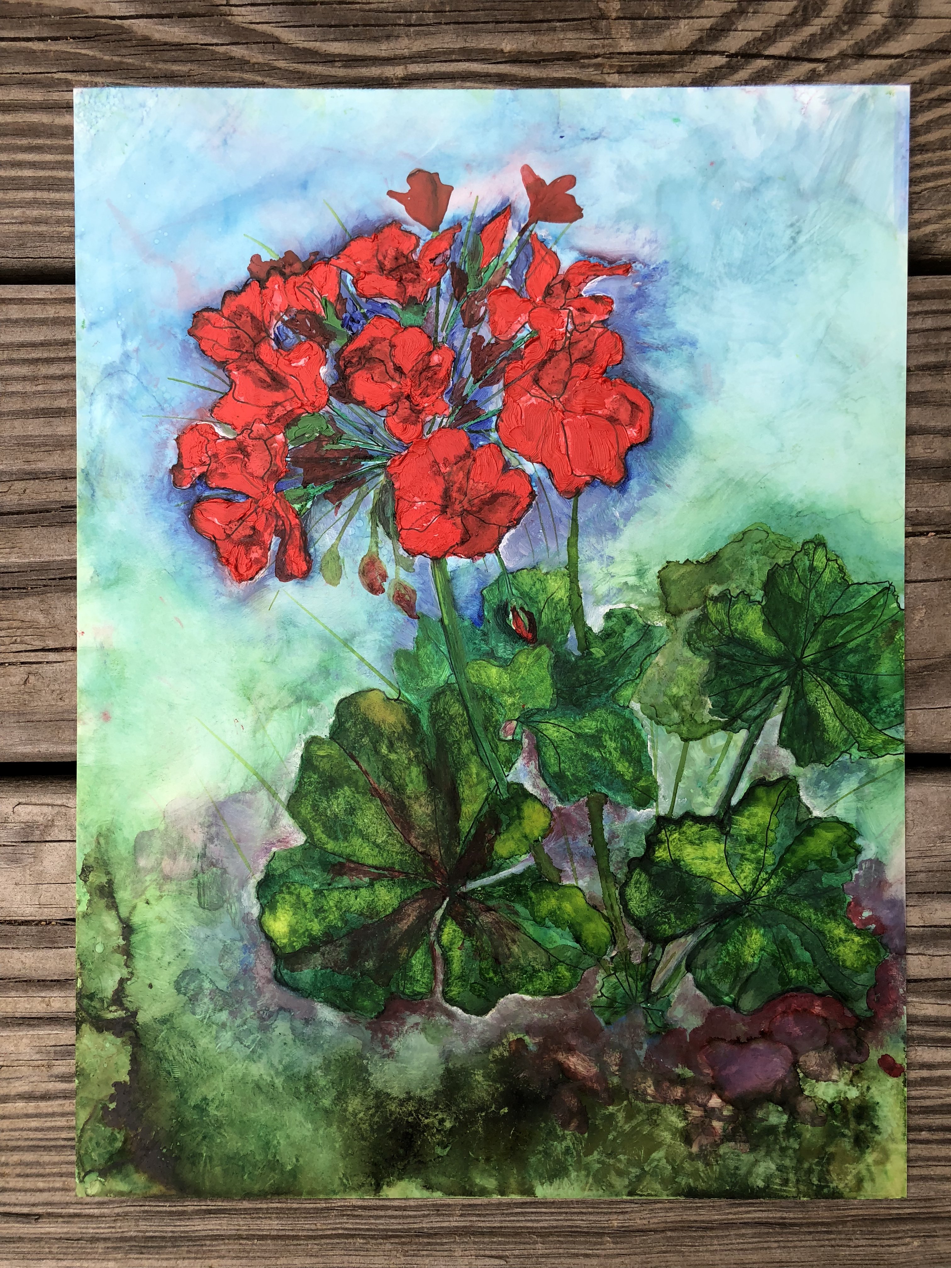 A vibrant red geranium greeting card featuring a mixed media painting with pen, oil paints, and alcohol inks, displayed with a white envelope.