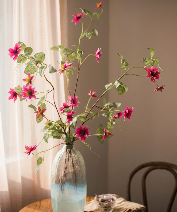 A 40-inch tall German Clematis flower stem in rose pink, featuring seven lifelike silk flowers and green leaves, perfect for home decor.