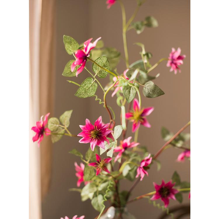 A 40-inch tall German Clematis flower stem in rose pink, featuring seven lifelike silk flowers and green leaves, perfect for home decor.