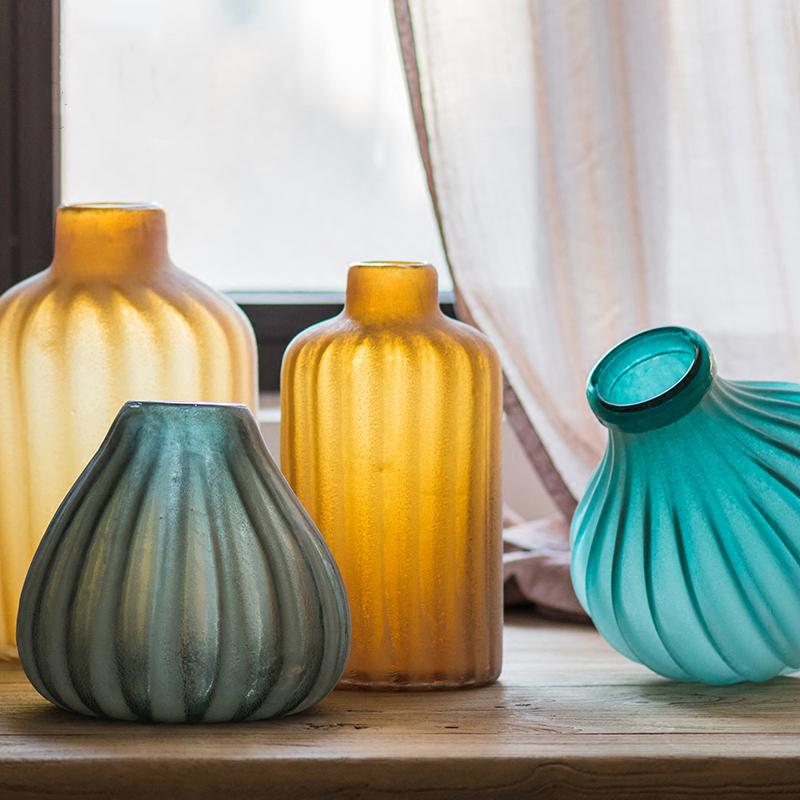 A beautifully crafted hand blown frosted art glass vase in yellow, blue, and gray, showcasing unique textures.