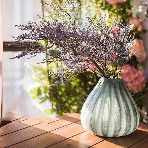 A beautifully crafted hand blown frosted art glass vase in yellow, blue, and gray, showcasing unique textures.