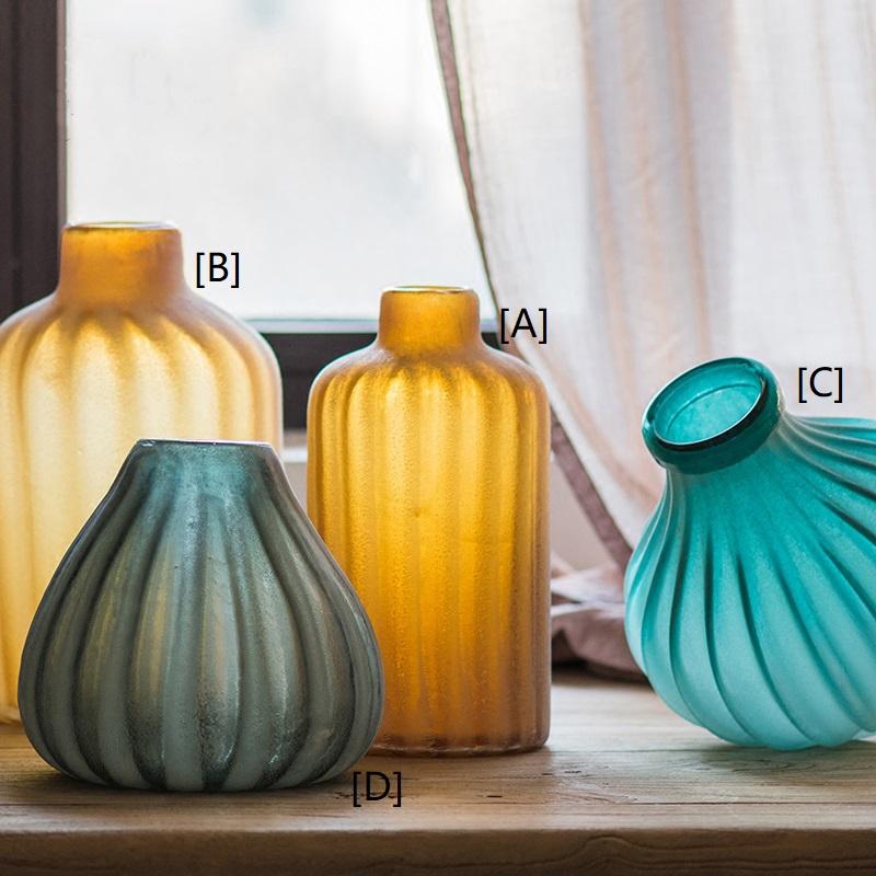 A beautifully crafted hand blown frosted art glass vase in yellow, blue, and gray, showcasing unique textures.