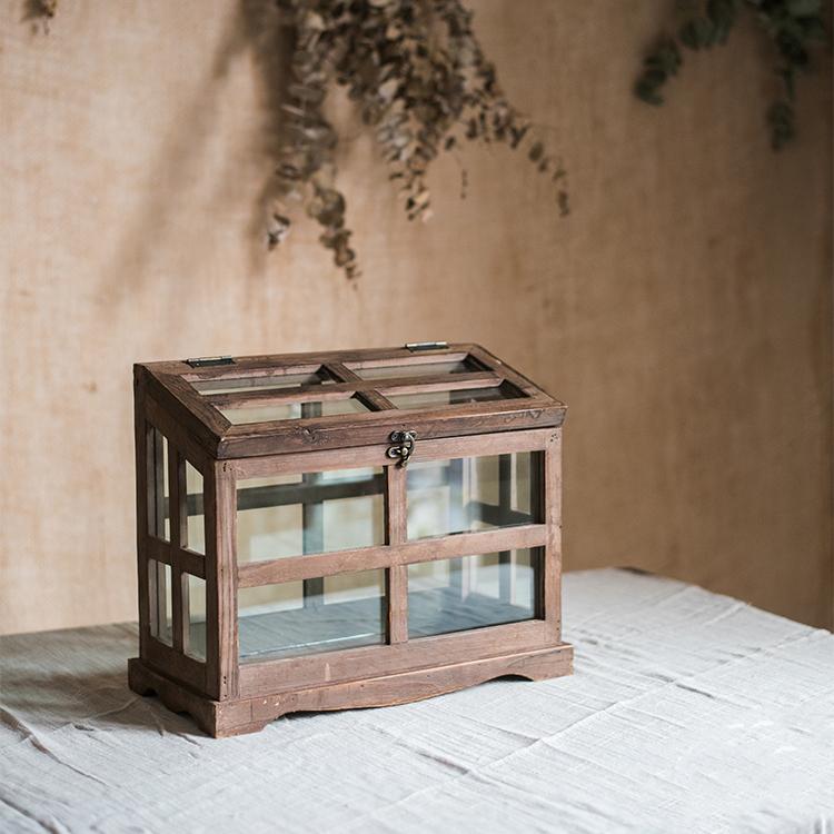 A stylish Glass Wood Display Box showcasing collectibles, featuring a clear glass top and a wooden base in brown sycamore.