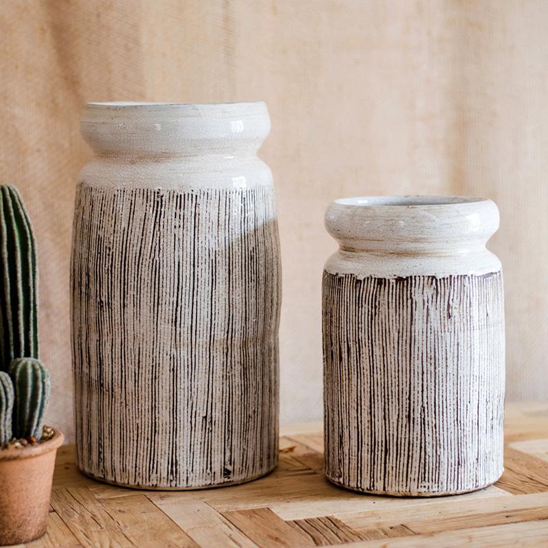 Handmade glazed ceramic vase with abstract brown stripes on a white background, showcasing a unique design and textured finish.