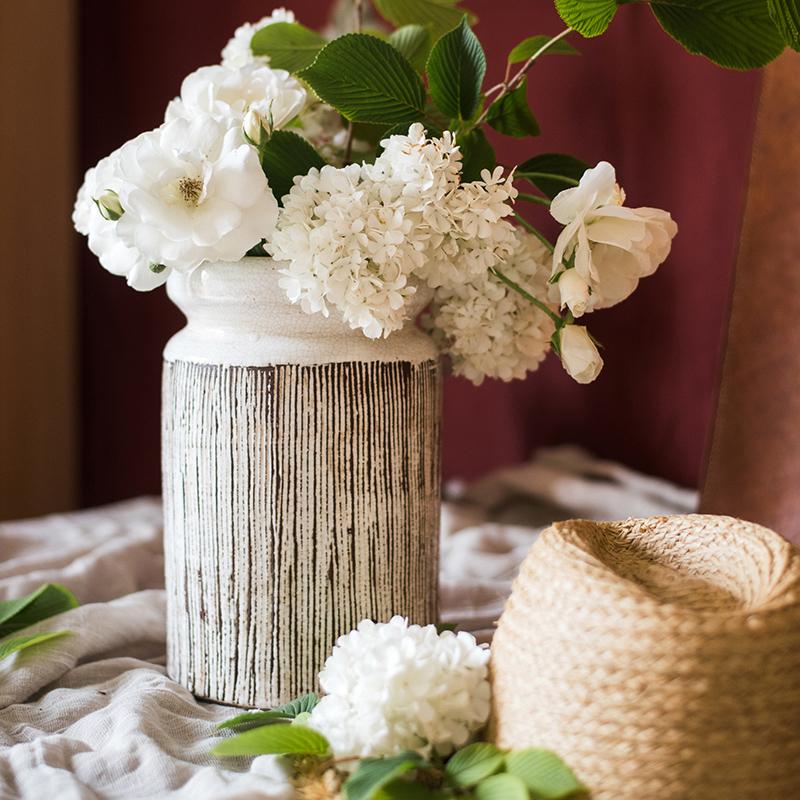 Handmade glazed ceramic vase with abstract brown stripes on a white background, showcasing a unique design and textured finish.